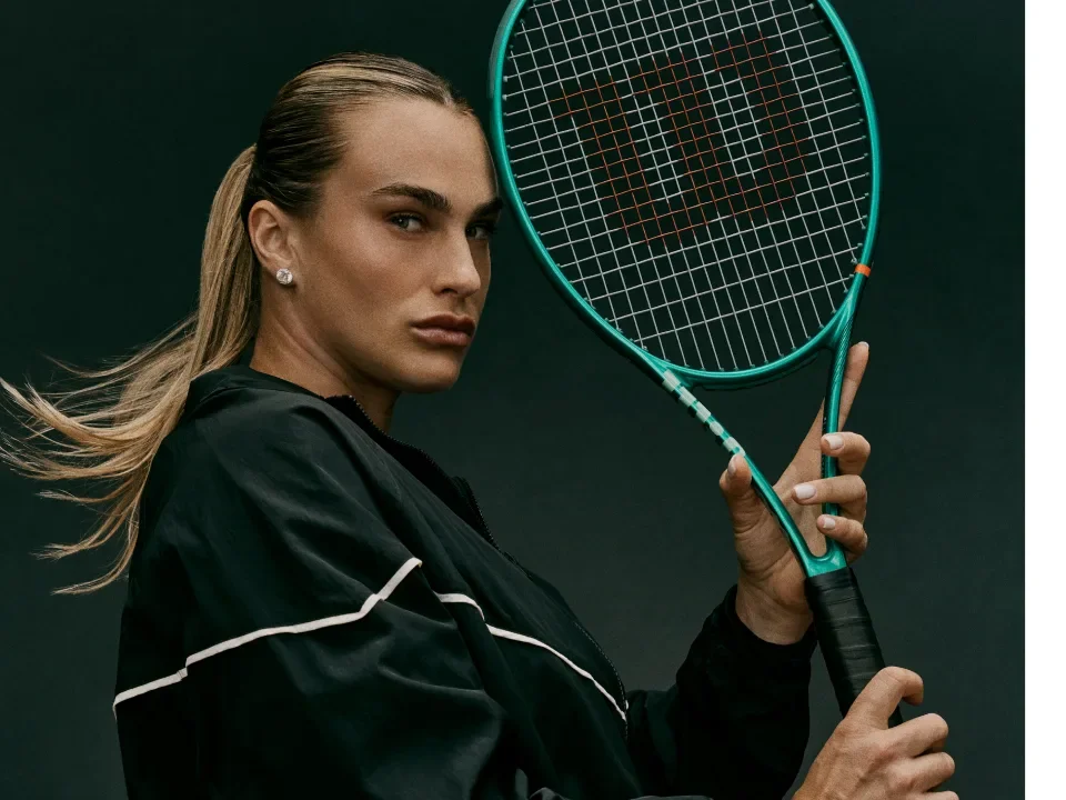 A Wilson professional player holding a green Wilson Blade tennis racket