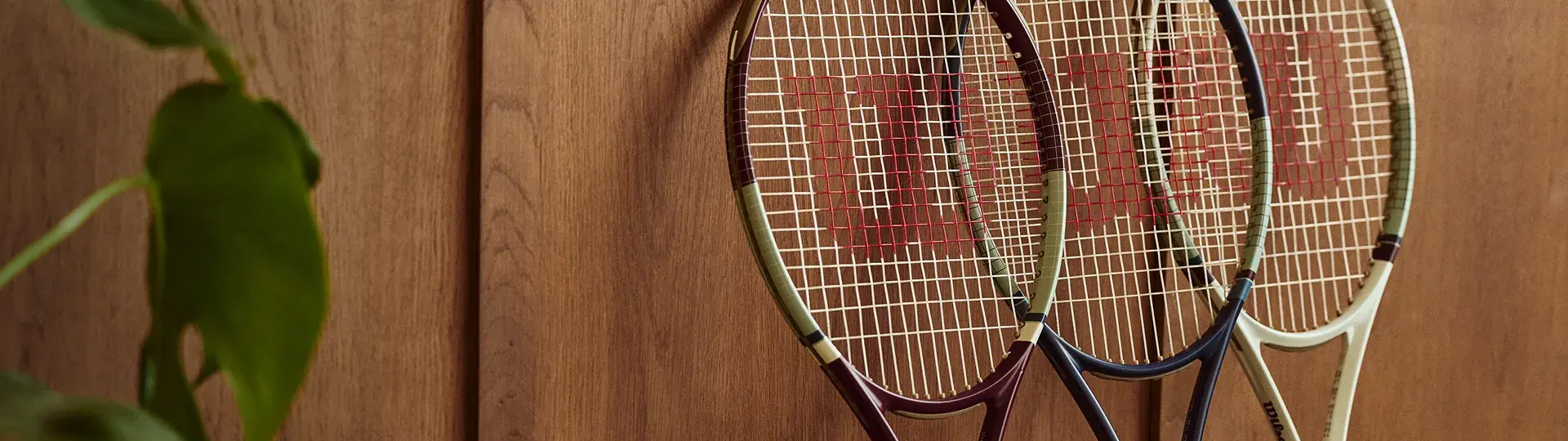 Wilson tennis rackets hanging on a wooden wall